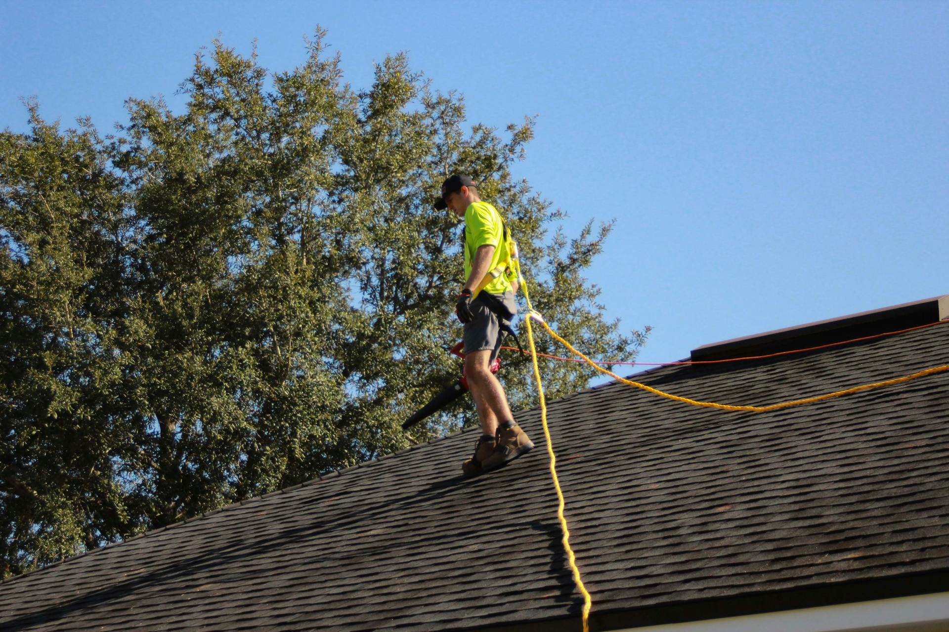 Professional roofer on residential roof with safety harness — roofing SEO services that win leads
